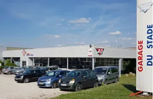 Bâtiment de garage automobile gris avec logo rouge AD et voitures garées à Auneau en Eure-et-Loir 28