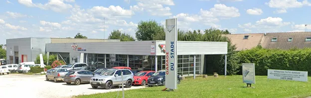 Garage automobile Garage du Stade avec des voitures en stationnement sous un ciel nuageux à Auneau en Eure-et-Loir 28